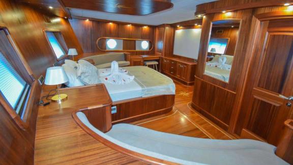 Luxurious cabin with a large bed and cozy couch, perfect for relaxing sea voyages on the Gulet Baba Can.