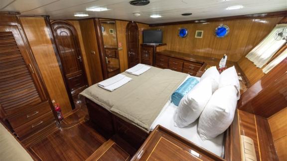 Hochwertig ausgestattete Master-Kabine mit Doppelbett und TV auf der Yacht Kayhan, ideal für Entspannung.