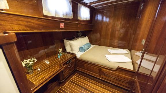 Small but comfortable cabin on Gulet Ceylan with double bed and wooden furniture.