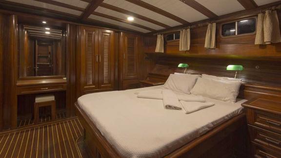 Stylishly furnished cabin with a large bed, wood panelling.