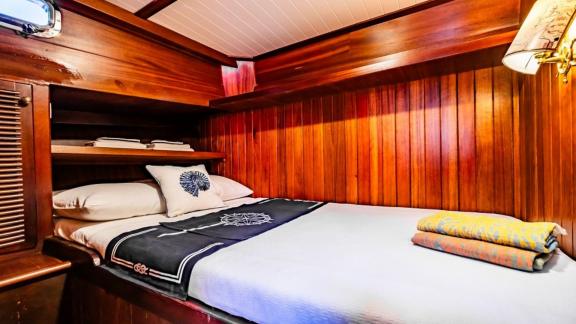 Cabin with a comfortable double bed and elegant wood paneling on Gulet Golden Joy in Bodrum.