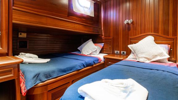 Cozy twin bed cabin of the 24-meter Gulet Sani Kaptan 2 with wood paneling, ideal for a comfortable stay in Bodrum, Turk