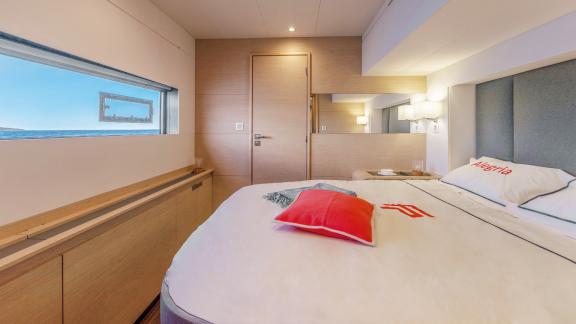 Gemütliches Schlafzimmer auf dem Katamaran Serenissima mit Panoramablick auf das Meer.