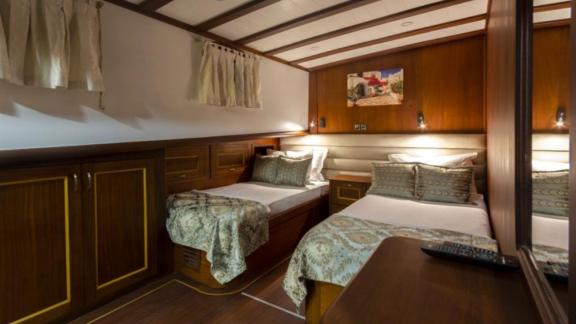 Double cabin on the gulet Smyrna with two cosy beds and elegant wooden furnishings.