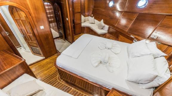 Stylish master cabin with a large bed and cozy seating areas on the Gulet Optimist in Bodrum.