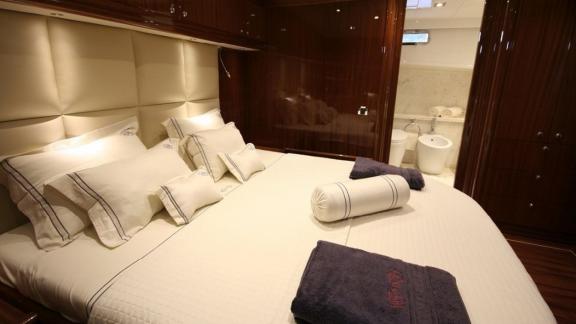 High-quality cabin of the Gulet Didi with large bed, elegant wood panelling and direct access to the bathroom.