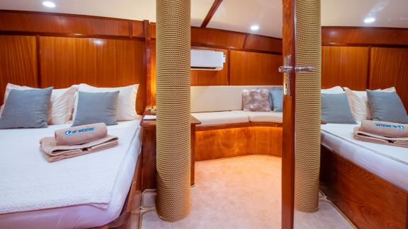 The double cabin on Gulet Rüya with two comfortable beds, seating area, and stylish wooden interior.