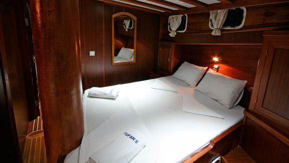 Cozy double cabin on Gulet Tufan 5 with high-quality linens and elegant wood paneling.