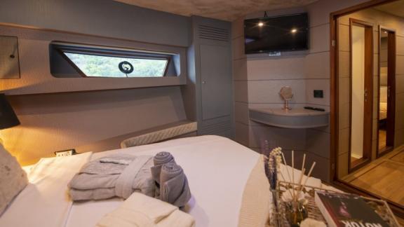 Das moderne Schlafzimmer der Motoryacht Golden Blue ist mit einem Fernseher und einem bequemen Bett ausgestattet.