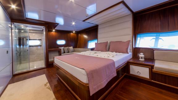 The cabin features a luxurious bed, stylish furniture, and an en-suite bathroom for maximum comfort.