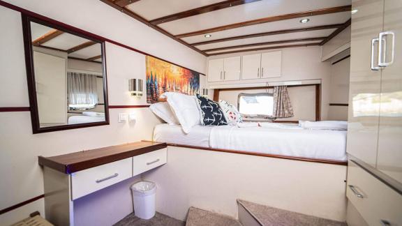 Tastefully decorated bedroom with a double bed and mirror dresser on the Gulet Azura.