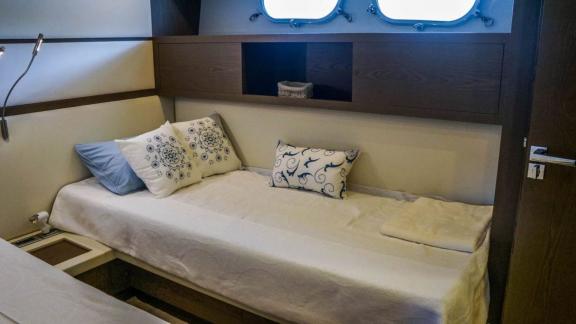 Komfortable Einzelkabine der Motoryacht Kuum mit bequemem Bett und Meerblick.