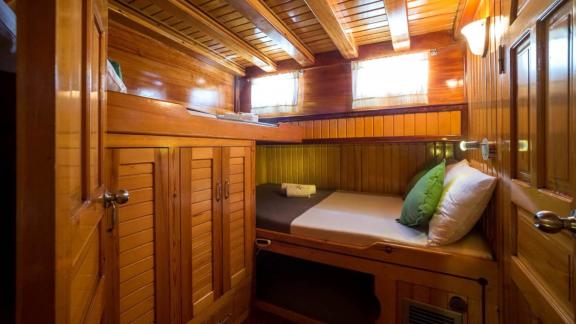 Practical and cozy cabin with a single bed and wood paneling. Ideal for a comfortable sea journey.