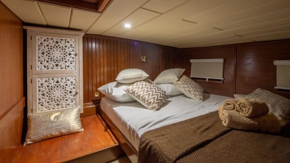 Cosy cabin with luxurious bed linen and stylish wooden elements.