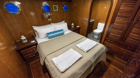 Gemütliche Gästekabine mit Doppelbett und eigenem Bad auf der Yacht Kayhan, ideal für entspannten Urlaub.