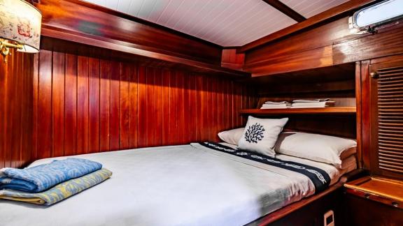 Cozy cabin with double bed and wooden walls on Gulet Golden Joy in Bodrum.