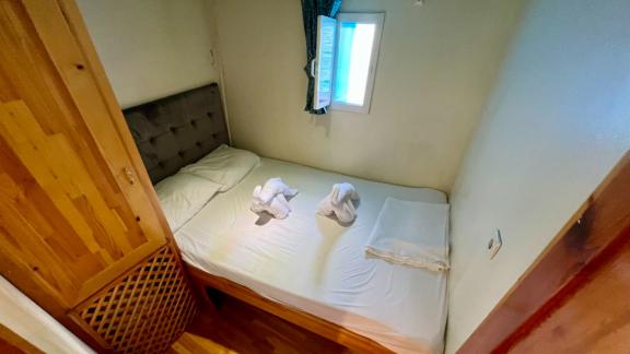 Komfortable Kabine auf der Gulet Simi mit Doppelbett, Fenster und eleganter Holzausstattung, ideal für erholsame Nächte.