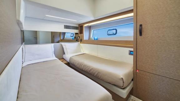 The comfortable twin bed bedroom of the motor yacht Shaft features modern decor and large windows.