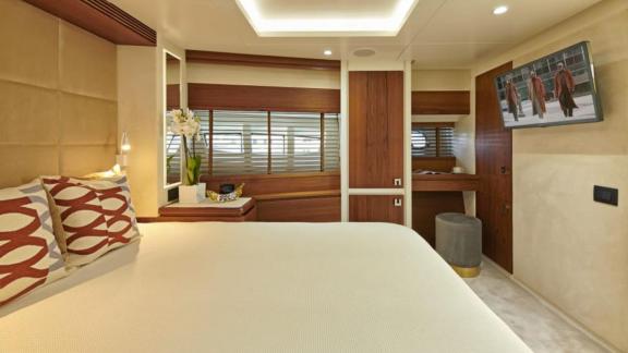 Comfortable master cabin with large bed, TV, and stylish wood accents on motor yacht La Fenice.