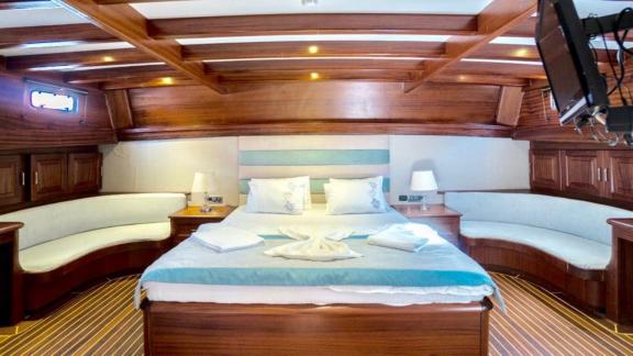 Spacious and elegant cabin on the Gulet Freedom in Marmaris with luxurious bed and stylish furnishings.