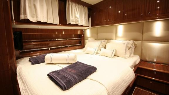 Luxurious cabin of the Gulet Didi with large bed, wood panelling.