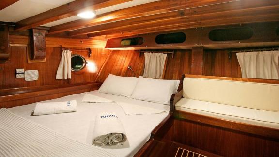 Classic double cabin on Gulet Tufan 5 with wood paneling and natural light, offering an authentic sailing experience.