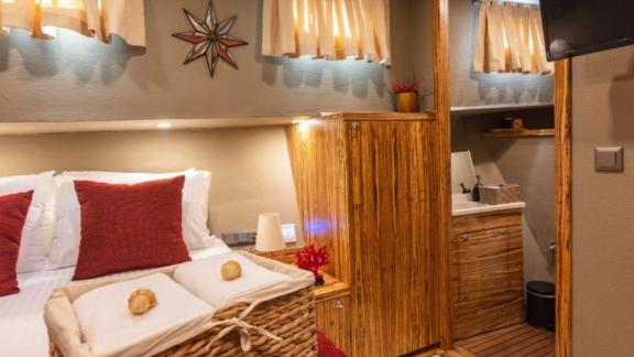 This stylish cabin in warm wood tones features a comfortable double bed and a private bathroom.