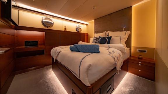 A warm, stylish yacht cabin with a comfortable bed and soft lighting