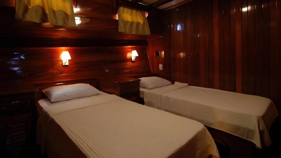 Wooden cabin with two single beds and ambient lighting on Gulet Sunworld 8 in Bodrum.