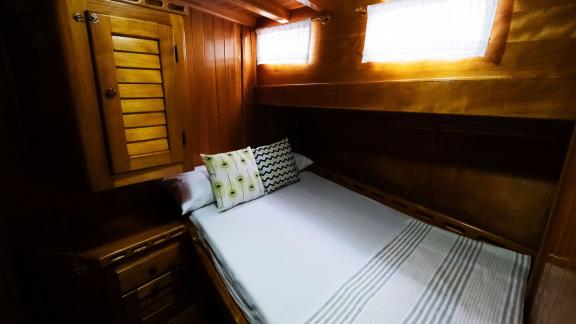 Cozy double cabin on Gulet Pronto White with stylish pillows and warm wood decor.