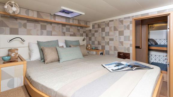 Large double bed with adjacent sleeping area and modern patterned walls.