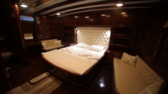 Exclusive suite of the Gulet Doris with upholstered headboard and comfortable amenities.