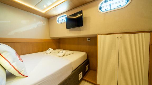 Cozy guest cabin on Ok Ay with a double bed, wardrobe, and TV for a relaxing stay in Fethiye.