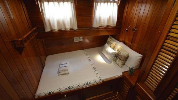 Comfortable double cabin on Gulet Tufan 5 with warm wood tones and soft lighting for a relaxing ambiance.