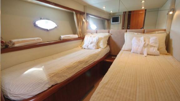 This cabin of the Distraction motor yacht features two comfortable single beds.