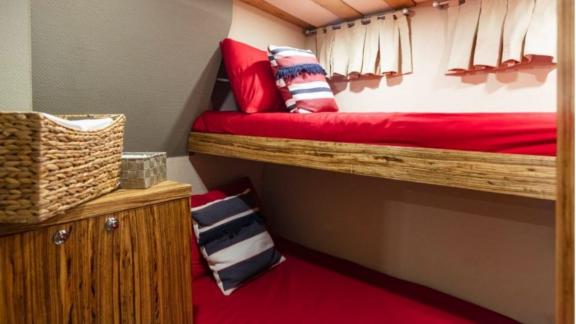 This cabin features cozy bunk beds with nautical pillows, perfect for children or friends.