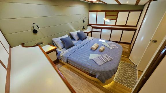 Elegant guest cabin on Gulet Arni with a comfortable bed and stylish decor.