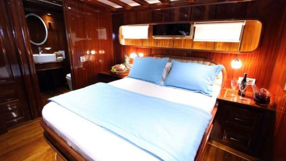 The comfortable cabin of the gulet Dear Lila offers a double bed and an adjoining bathroom.