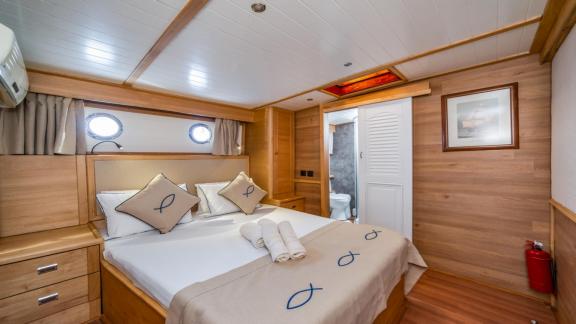 A comfortable bedroom on the gulet yacht Amazon Solo with double bed and en-suite bathroom.