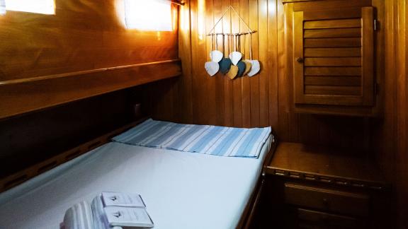 Cozy double cabin on Gulet Pronto White, decorated with nautical elements and warm wood.