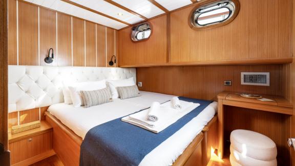 Comfortable cabin of the gulet Gozdem The One with double bed, wood panelling and stylish interior.