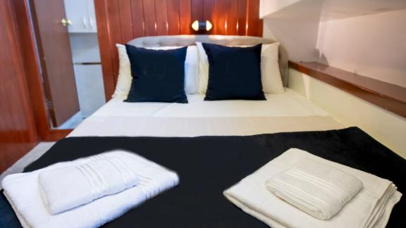 Comfortable bedroom on Guletcharter Hülyam 2 in Göcek with fresh towels and stylish decor.