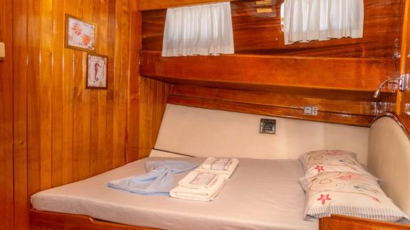 Gemütliches Schlafzimmer mit warmem Holzdekor und Doppelbett auf der Gulet Deniz Kızı A.