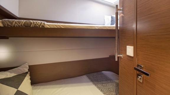 The cozy cabin of the Lagoon 560 in Athens features bunk beds, ideal for extra sleeping space in a warm, inviting atmosp