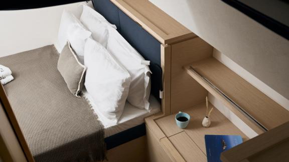 Cozy cabin on the catamaran Pi 2 in Athens with a comfortable bed and a practical desk.