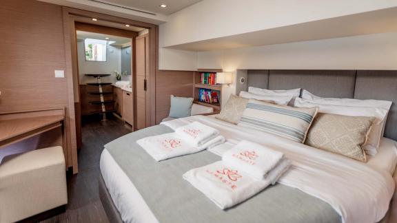 Comfortable double bed in the cabin, adjacent to a private bathroom