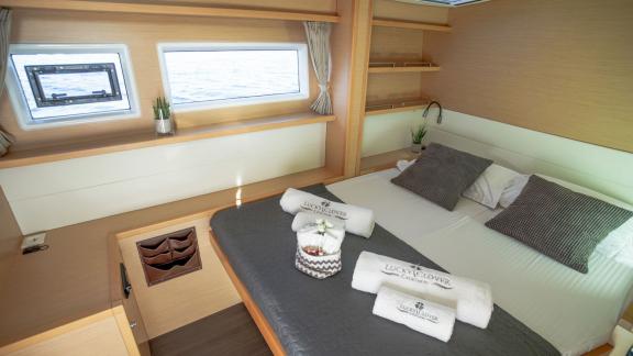 Helles Schlafzimmer im Katamaran Lucky Clover mit Meerblick, komfortablem Doppelbett und stilvollem Design.