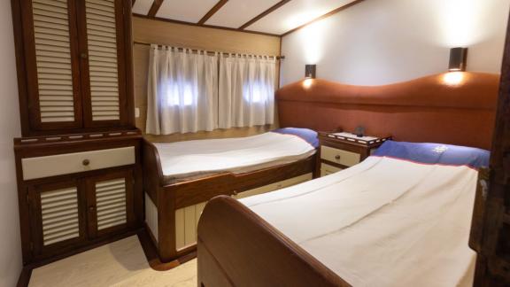 Cozy twin cabin with two single beds and wardrobe on Yacht Kanarya.