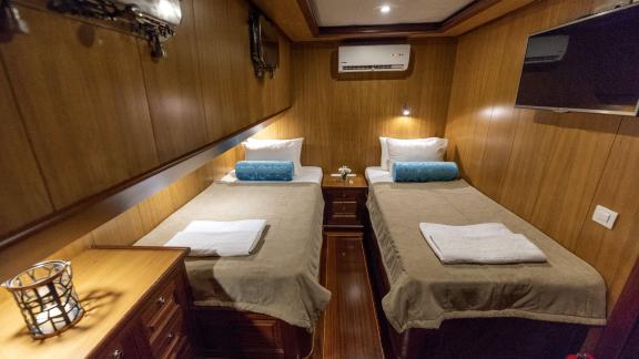 Elegant cabin with two single beds and TV.