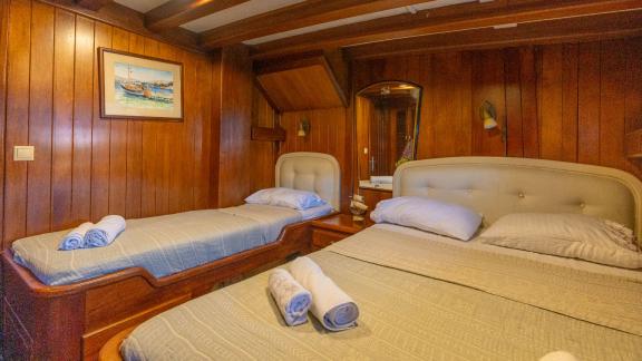 Comfortable twin cabin of the Serenad yacht with two single beds and classic wood decor.